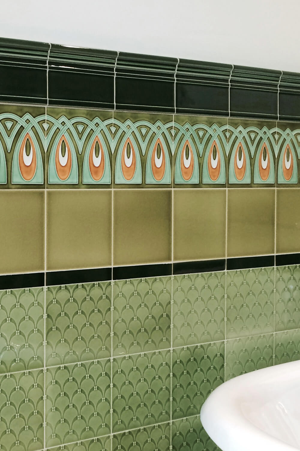 Bad mit Jugendstilfliesen mit geometrischen Ornament in grün, hellgrün und orange, Rapport, Entwurf: Grohner Wandplattenfabrik 1900