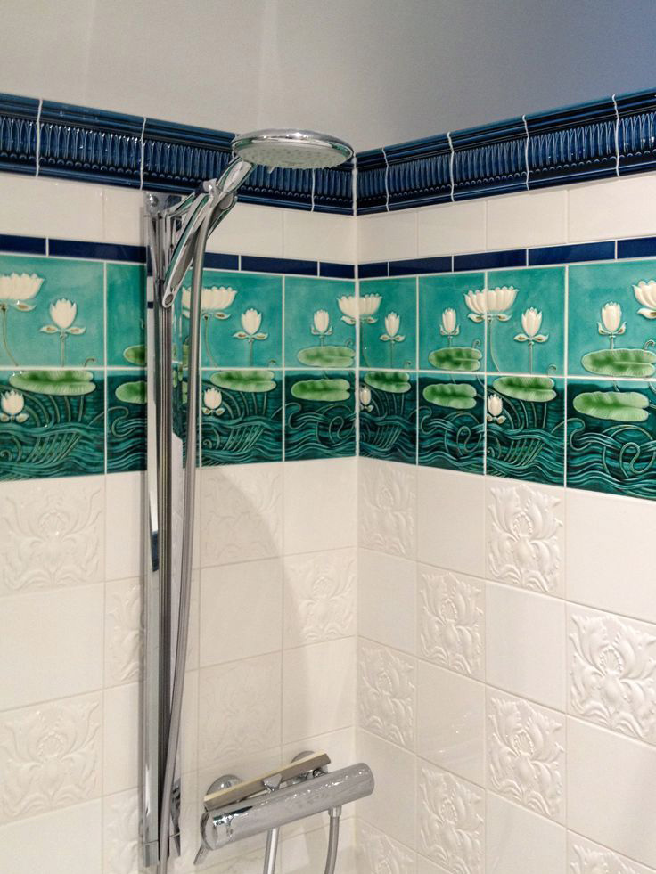 Seerosenmotiv zwischen weißen und blauen Wandfliesen in einer Dusche